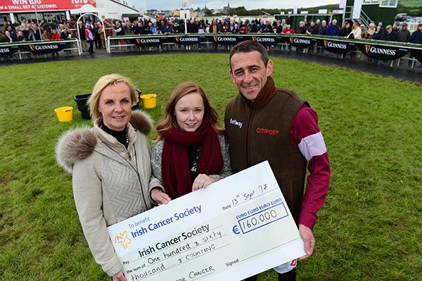 Una Manning (left) and Davy Russell presenting the cheque to Emma Hayden from the Irish Cancer Society
