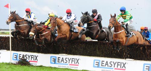 Nearly Nama'd and Roger Loughran (right, blue cap) jump the first fence